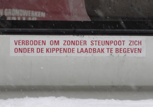 "verboden om zonder steunpoot zich onder de kippende laadbak te begeven"